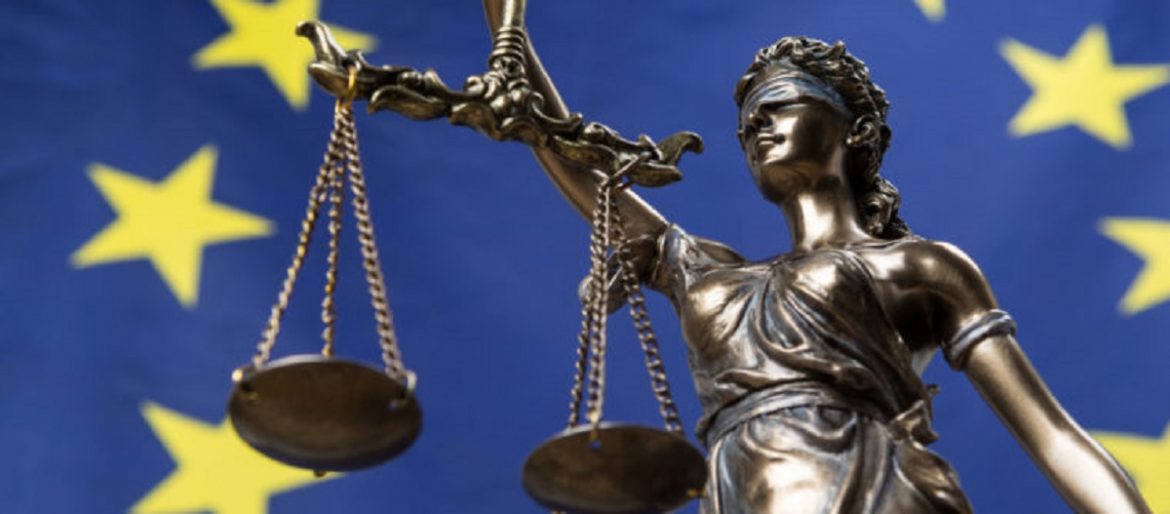 Statue of the blindfolded goddess of justice Themis or Justitia, against an European flag, as a legal concept